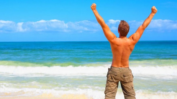 man_celebrating_beach-the grant study