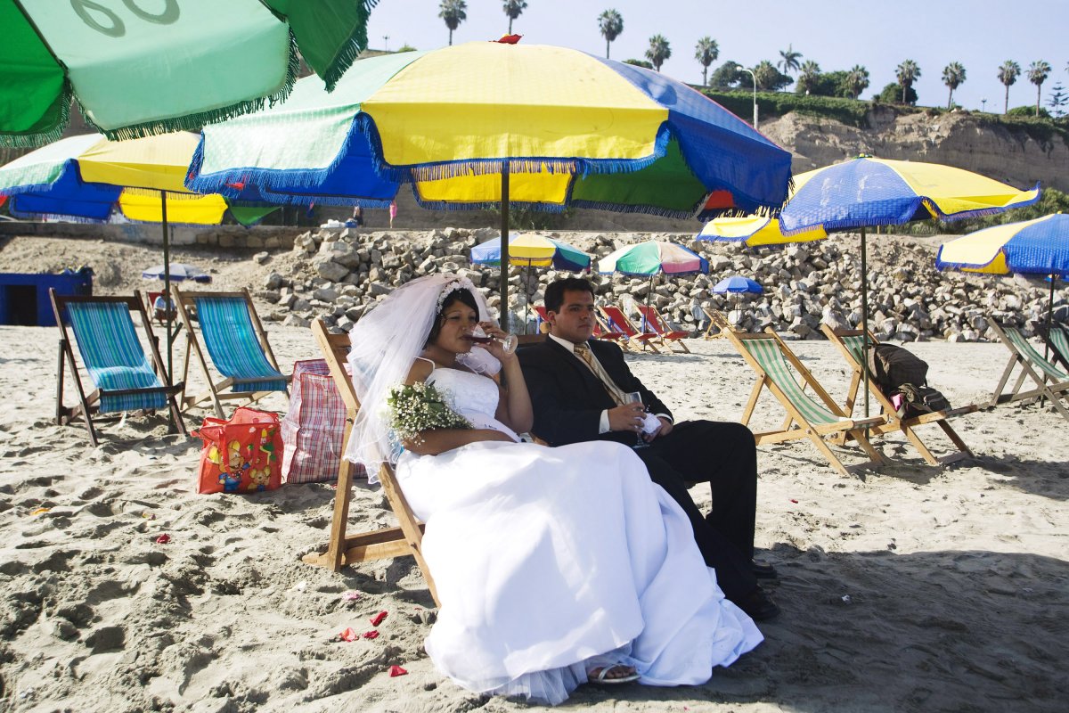 a-bride-and-a-groom-sit-on-a-beach-in-lima-before-a-ritual-with-shamans-for-saint-valentines-day