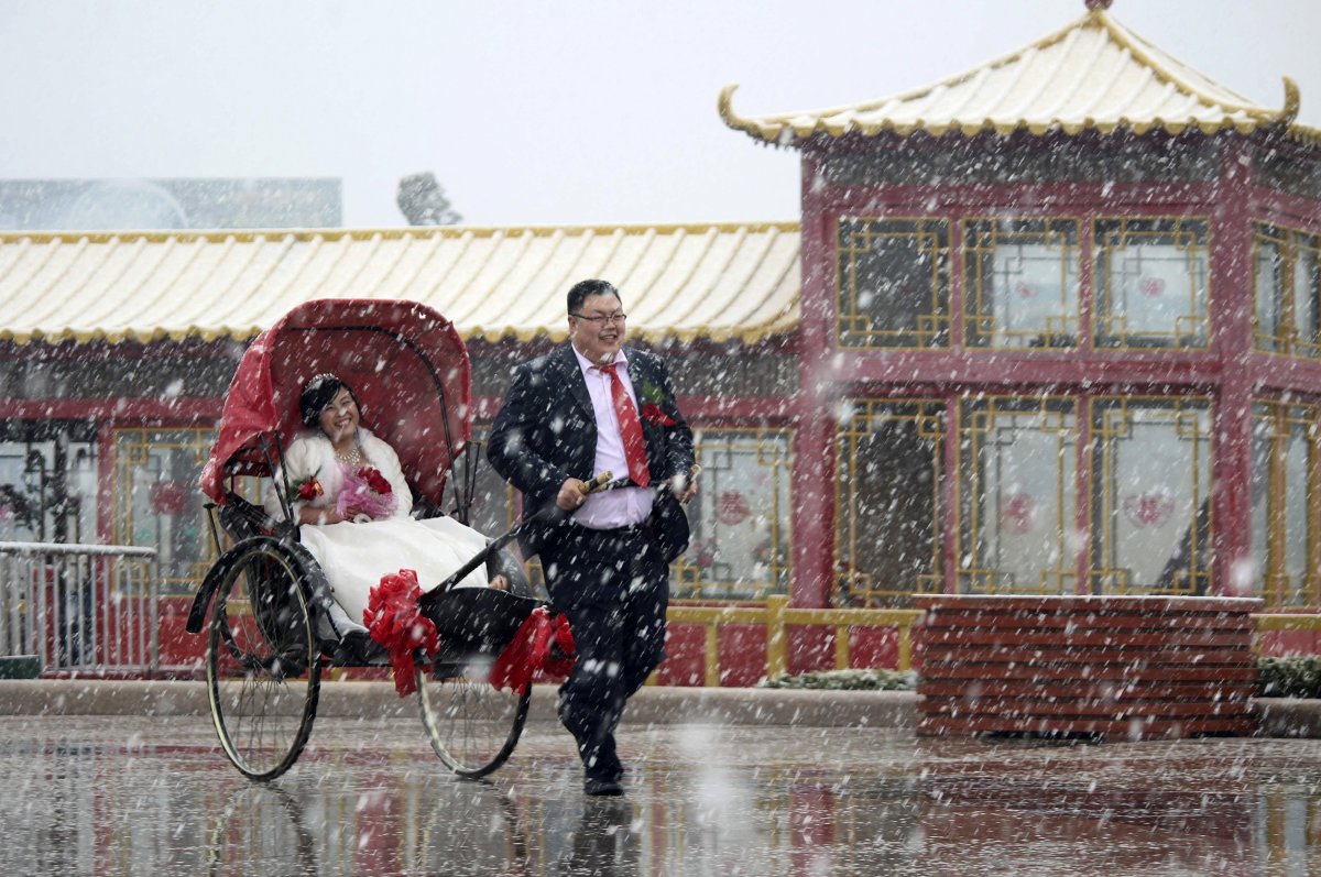 a-man-pulls-a-rickshaw-carrying-his-wife-as-it-snows-in-weihai-shandong-province-in-china