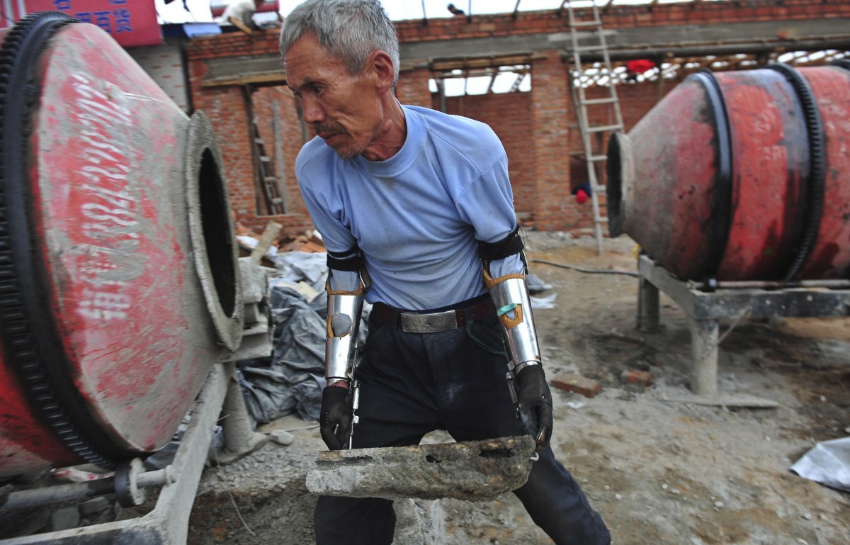 sun-jifa-moves-a-brick-as-he-works-to-build-his-new-house-in-yong-ji-county-jilin-province-september-25-2012-chinese-farmer-sun-who-lost-his-forearms-in-a-dynamite-fishing-accident-32-years-ago