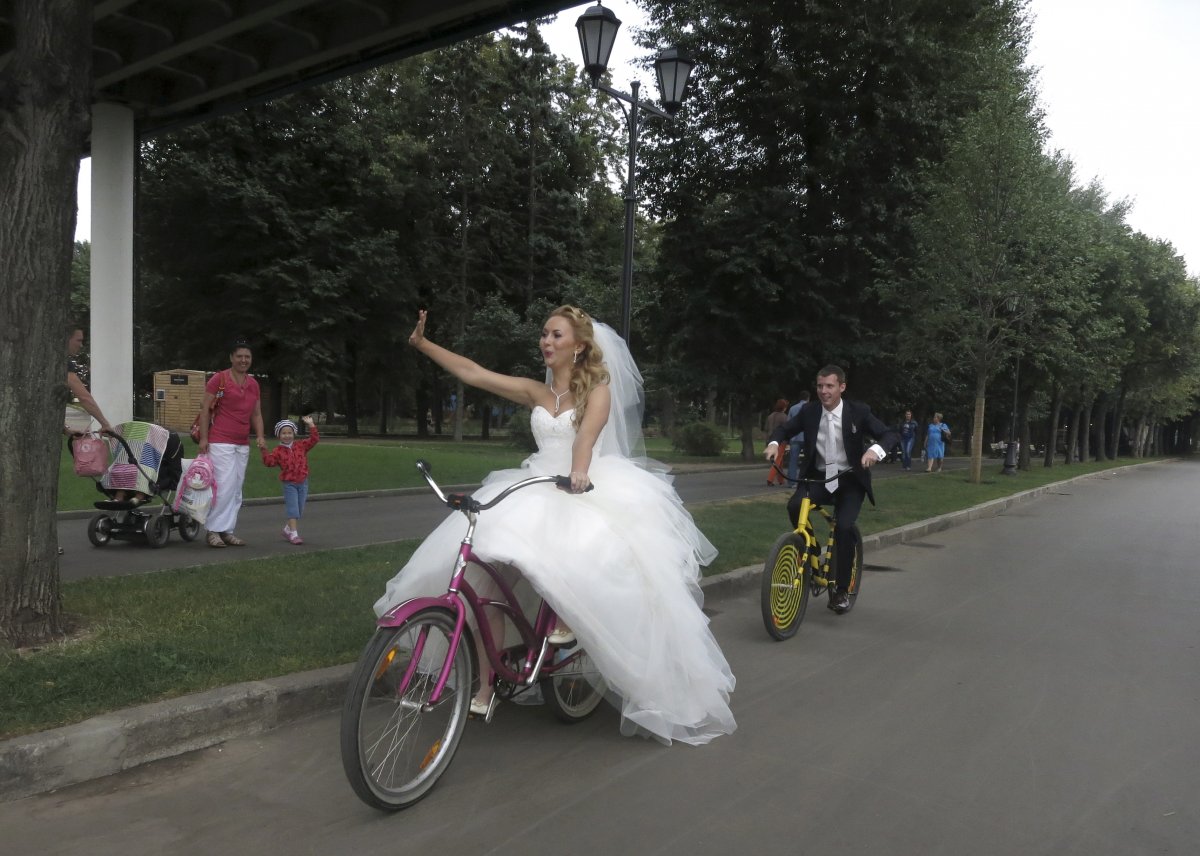 yelena-babkini-and-her-husband-wave-as-they-ride-through-gorky-park-on-bicycles-after-having-been-married-earlier-in-the-day-in-moscow