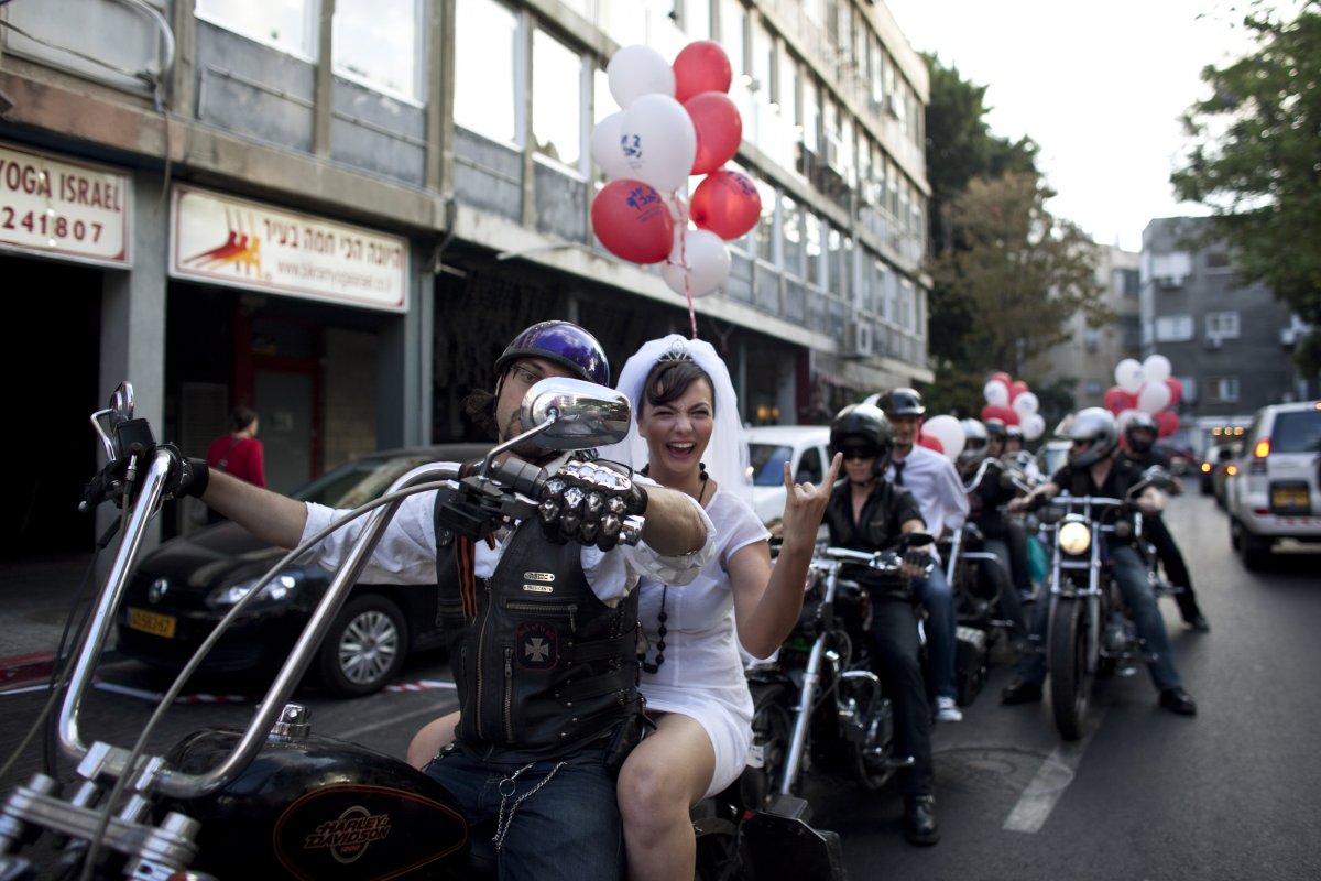 yulia-tagil-sits-on-the-backseat-of-a-bike-as-she-arrives-for-her-wedding-ceremony-in-tel-aviv