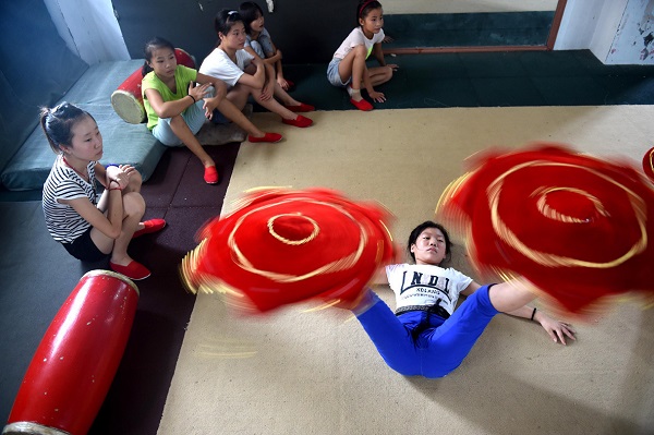 06 Aug 2015, China --- (150806) -- LINQUAN, Aug. 6, 2015 (Xinhua) -- A girl practises basic skills at an acrobatic school in Linquan, east China's Anhui Province, Aug. 6, 2015. Acrobatics has become a major way for most local people to acquire a well-off life, and plenty of leftover children here are sent to acrobatic school at a very young age. (Xinhua/Liu Junxi) (hgh) --- Image by © Liu Junxi/Xinhua Press/Corbis