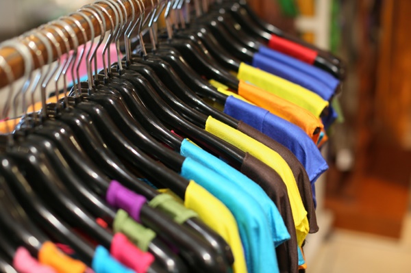 A rack of colorful shirts hanged for sale at a fair