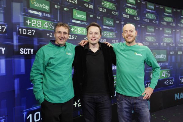 IMAGE DISTRIBUTED FOR SOLARCITY - SolarCity Founder & CEO Lyndon Rive, Chairman Elon Musk, and SolarCity Founder & COO Peter Rive celebrate the companyís IPO by posing for a photo at the NASDAQ Stock Market on Thursday, Dec. 13, 2012 in New York. SolarCity is a leader of distributed clean energy and will trade under SCTY. (Mark Von Holden/AP Images for SolarCity)  ORG XMIT: CPA106