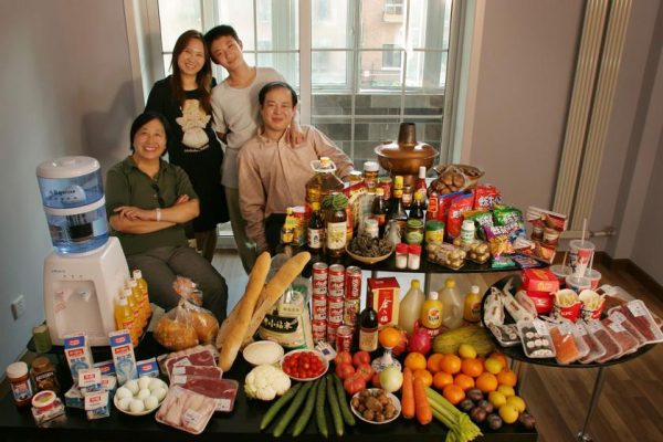 CHI103.0001.xxf1rw (MODEL RELEASED IMAGE) The Dong family in the living room of their one-bedroom apartment in Beijing, China, with a week’s worth of food. Seated by the table are Dong Li, 39, and his mother, Zhang Liying, 58, who eats with them a few times a week. Behind them stand Li’s wife, Guo Yongmei, 38, and their son, Dong Yan, 13. Cooking method: gas stove. Food preservation: refrigerator-freezer. Favorite food—Dong Yan: yuxiang rousi—fried shredded pork with sweet and sour sauce. /// The Dong family is one of the thirty families featured in the book Hungry Planet: What the World Eats (p. 74). Food expenditure for one week: $155.06 USD. (Please refer to Hungry Planet book p. 75 for the family’s detailed food list.)