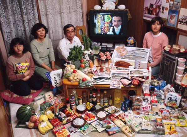 JAP01.0001.xxf1s (MODEL RELEASED IMAGE) The Ukita family—Sayo Ukita, 51, and her husband, Kazuo Ukita, 53, with children Maya, 14 (holding chips) and Mio, 17—in their dining room in Kodaira City, Japan, with one week’s worth of food. Cooking methods: gas stove, rice cooker. Food preservation: small refrigerator-freezer. Favorite foods—Kazuo: sashimi. Sayo: fruit. Mio: cake. Maya: potato chips. /// The Ukita family is one of the thirty families featured in the book Hungry Planet: What the World Eats (p. 180). Food expenditure for one week: $317.25 USD. (Please refer to Hungry Planet book p. 181 for the family’s detailed food list.)