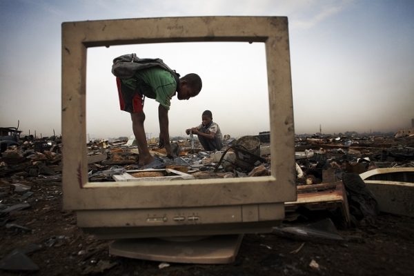 Children break apart CRT (cathode ray tube) monitors to salvage metal from inside at Agbogbloshie dump, which has become a dumping ground for computers and electronic waste from all over the developed world. Hundreds of tons of e-waste end up here every month. It is broken apart, and those components that can be sold on, are salvaged.