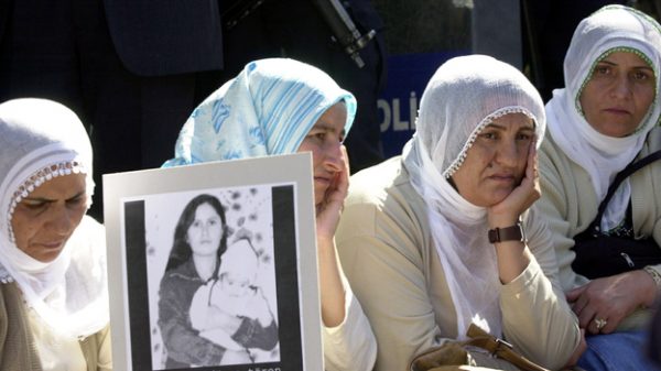A woman holds a photo of Guldunya Toren, an unmarried mother allegedly killed by her brothers for having a child out of wedlock, outside parliament in Ankara, Turkey, in 2004. Her case prompted huge protests and forced Turks to realize that the justice system often fails to protect at-risk women.