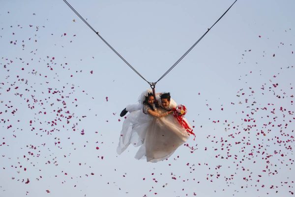 a-bride-and-groom-fly-while-attached-to-cables-during-a-wedding-ceremony-ahead-of-valentines-day-at-a-resort-in-ratchaburi-province-thailand