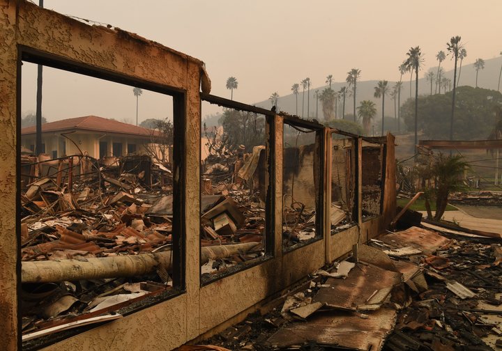 A wall stands in the burnt out Vista del Mar Hospital after the Thomas wildfire swept through Ventura, California on December 6, 2017. California motorists commuted past a blazing inferno Wednesday as wind-whipped wildfires raged across the Los Angeles region, with flames  triggering the closure of a major freeway and mandatory evacuations in an area dotted with mansions. / AFP PHOTO / Mark RALSTON
